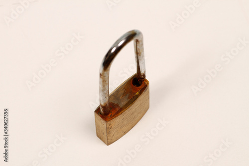 Rustproof padlock used for security. Rusty padlock used to lock the doors of places such as garage doors, warehouses. Rusty padlock. Old padlock made of brass and steel. photo