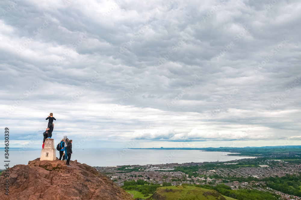 Obraz premium Unrecognizable tourists observing the panorama of Edinburgh from Arthur's Seat