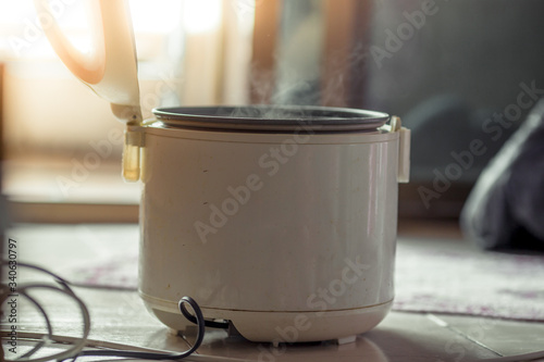 The blurred background of the smoke rising out of the rice cooker, the aroma of food fragrance, seen from the cooking in a condo or house.
