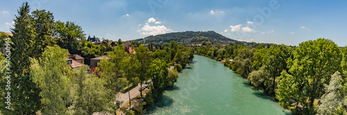 Bern, Switzerland - July 30, 2019: Aerial view of Aar from the Monbijoubrucke Bridge. Brige over the Aare river. Bern Switzerland. Gurten Park green hill on the background. Super wide angle panorama photo