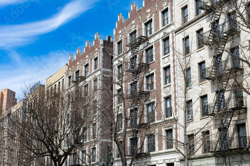 Row of Old Buildings with Fire Escapes in Harlem of New York City
