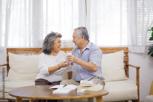 Foto senior woman brink glass of milk to older husband in living room while he working or reading