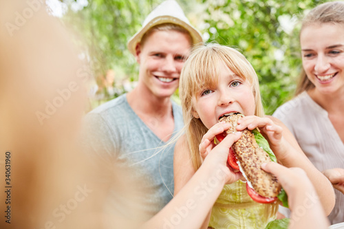 Hungry girl is eating a fresh baguette