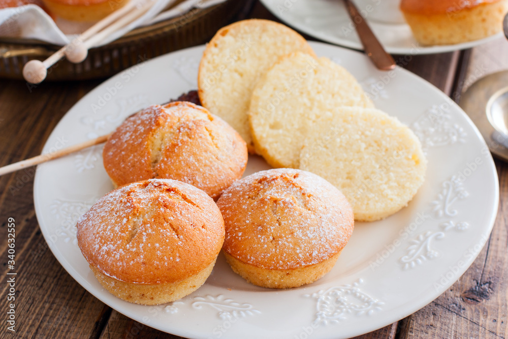 Homemade vanilla muffins sprinkled with icing sugar, selective focus Homemade vanilla muffins sprinkled with icing sugar, selective focus