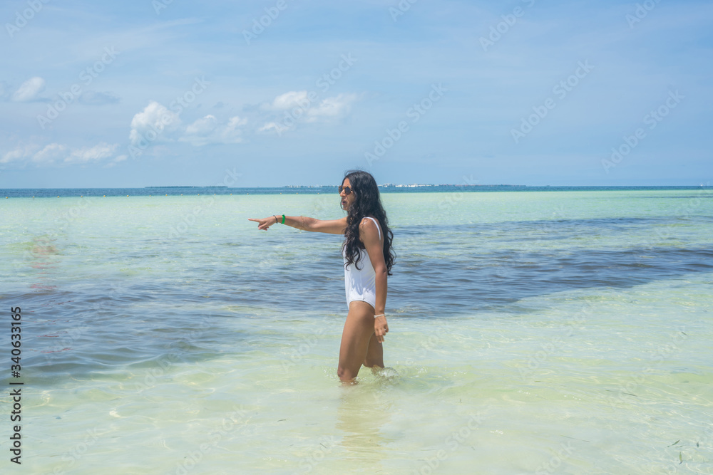 Young indian woman pointing sea in the beach Young indian woman pointing sea in the beach