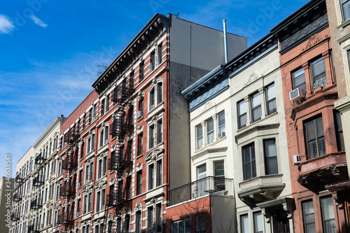 Row of Colorful Old Buildings with Fire Escapes in Harlem of New York City