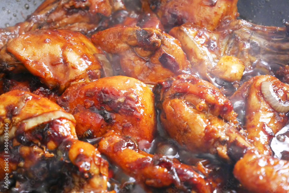 Fried chicken cooked with black soy sauce. The chicken pieces are fried over dry and then poured with soy sauce and onion.