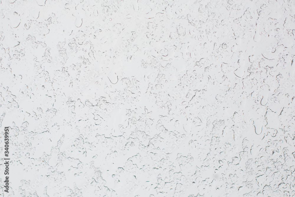 Texture of Frozen drops of condensed steam water drops on the transparent window glass. Clean background. Water vapor condenses on cold window glass and freezes into ice Texture of Frozen drops of condensed steam water drops on the transparent window glass. Clean background. Water vapor condenses on cold window glass and freezes into ice