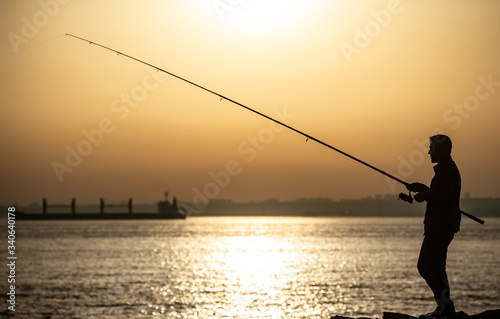 Fisherman at Bosphorus strait in Istanbul, Turkey during sunset