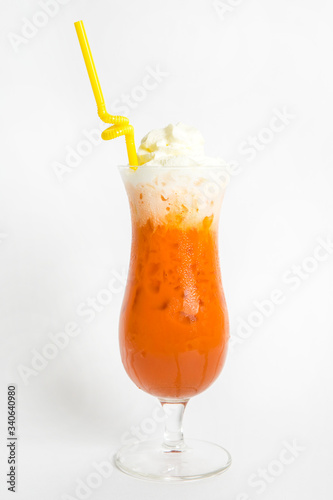 orange thai milk tea with ice top with wipe cream serve in tall glass and straw
