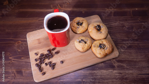 red coffee mug with cookies and coffee beans