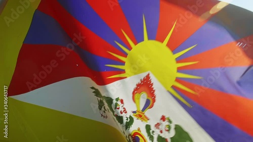 Flag of Tibet Waving in the wind close up shot, Sky and Sun and plants Background, 4K UHD Slow-Motion