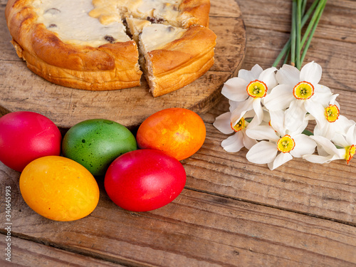 traditional romanian easter dish cozonac and pasca or sweetbread and cheese pie like on wooden table and colored easter eggs and flowers photo