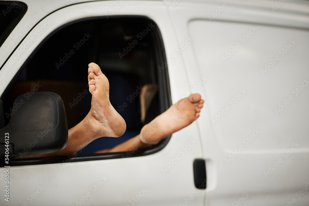 A worker rests his feet while sleeping in his van Stock Photo | Adobe Stock