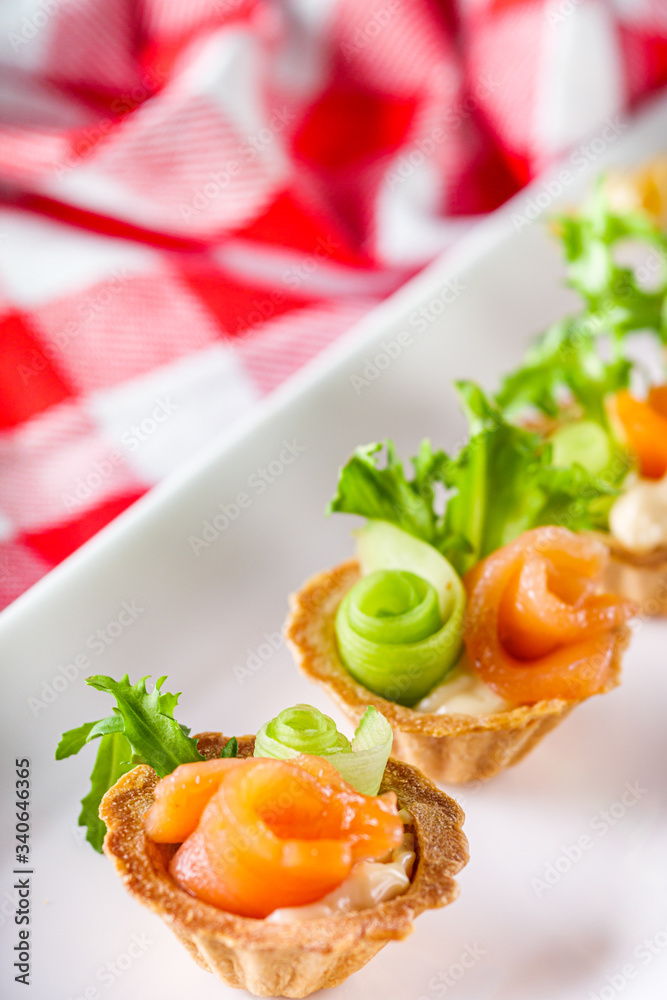 delicious snack tartlets on rustic wooden background