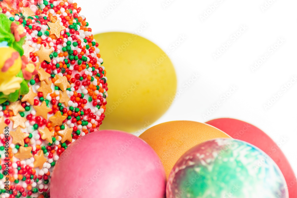 Fragment of Easter cake with colored eggs and a white background Fragment of Easter cake with colored eggs and a white background