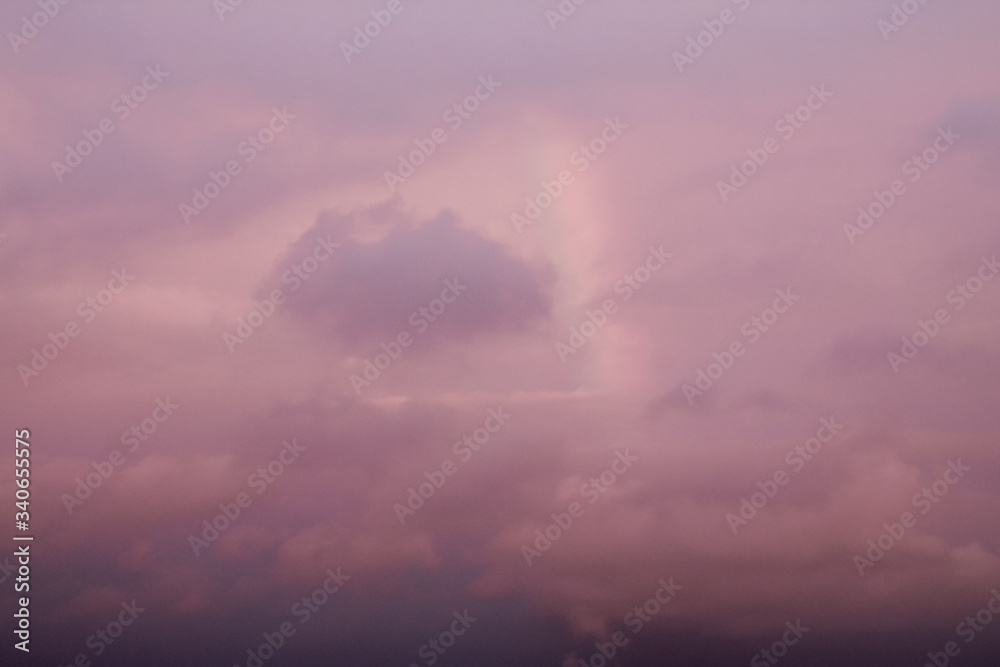 Obraz premium pink sunset over the city and a rainbow between the clouds