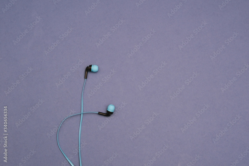 Thin blue headphones on a blue background. Space for text. Isolated Thin blue headphones on a blue background. Space for text. Isolated