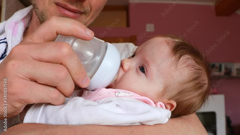 Father holding and feeding his baby from the milk bottle. Close up father feeding his baby. Father holding and feeding his baby from the milk bottle. Close up father feeding his baby.