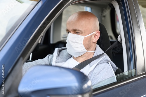 Man driving a car in medical protective mask. © Daniel Jędzura