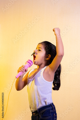Little girl with a mustache singing using her microphone
