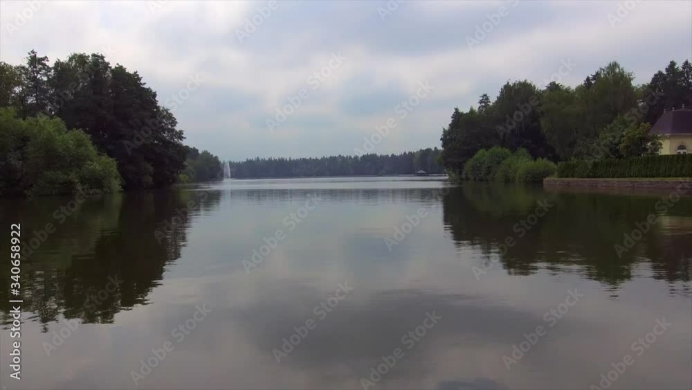 Shooting from above near water from throne flight between the trees over lake. Shooting from above near water from throne flight between the trees over lake.