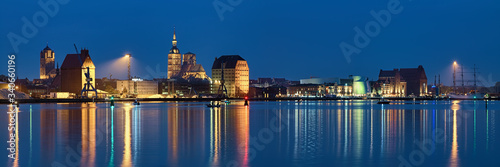 Stralsund, Germany. Panoramic view of the North Harbor in dusk with St. James Church (left), St. Nicholas Church (center), historical warehouses (right).