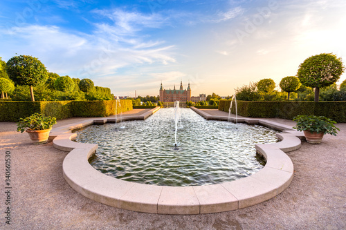 Sunset view of Frederiksbork palace castle with beautiful garden and fountain water at sunset time in Hillerod, near Copenhagen, Denmark, Europe, Scandinavia in summer