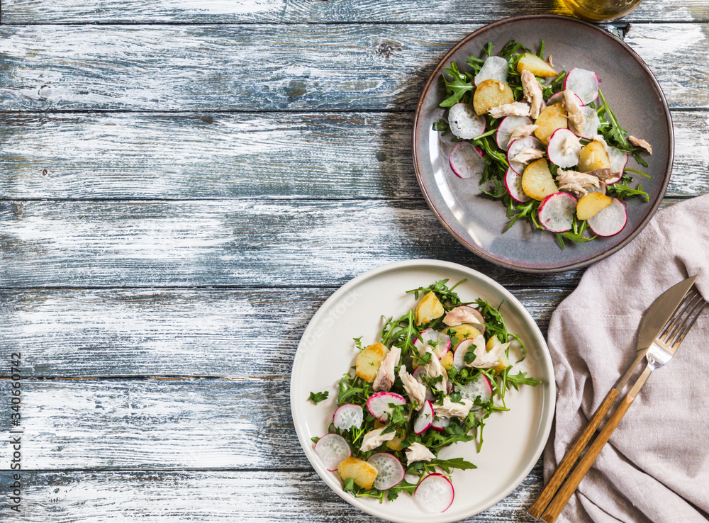 Fresh salad with radishes, potatoes, arugula and mackerel or tuna. diet concept Fresh salad with radishes, potatoes, arugula and mackerel or tuna. diet concept