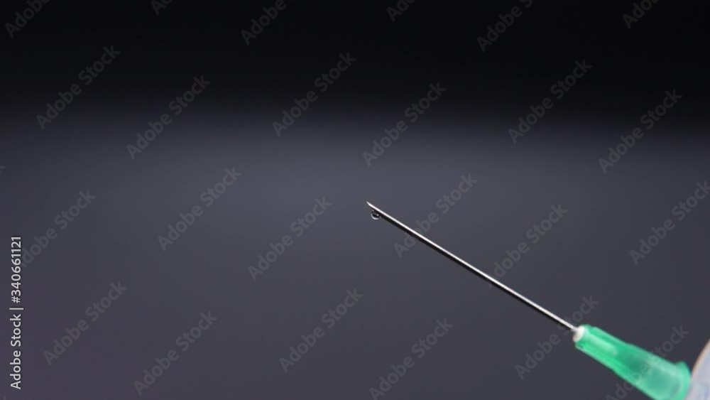 Medicine leaking from a syringe drop by drop. Medicine leaking from a syringe drop by drop.
