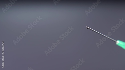 Medicine leaking from a syringe drop by drop.