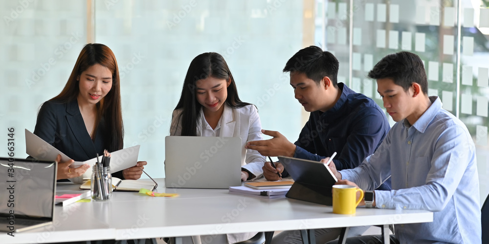 Photo of business people meeting with computer laptop and tablet while sitting together at the white meeting desk over modern conference room as background. Photo of business people meeting with computer laptop and tablet while sitting together at the white meeting desk over modern conference room as background.