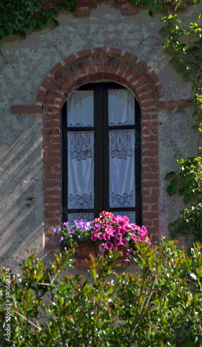 window with flowers,old,medieval,home, house, wall,exterior, facade, detail,glass, brick,europe,
