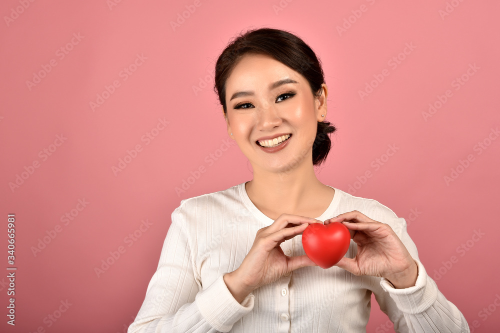 Gentle asian woman holding red heart, Happy smiling girl showing love sign to support and encourage, Cardiac health checkup. Gentle asian woman holding red heart, Happy smiling girl showing love sign to support and encourage, Cardiac health checkup.
