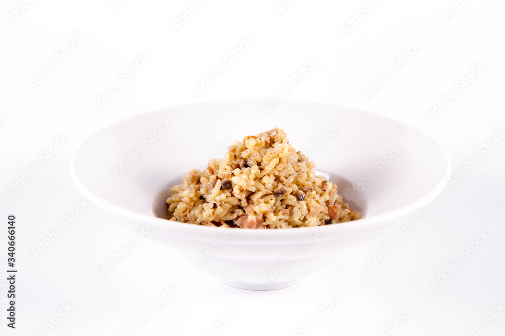Risotto with button mushroom and bacon on a plate on a white background Risotto with button mushroom and bacon on a plate on a white background
