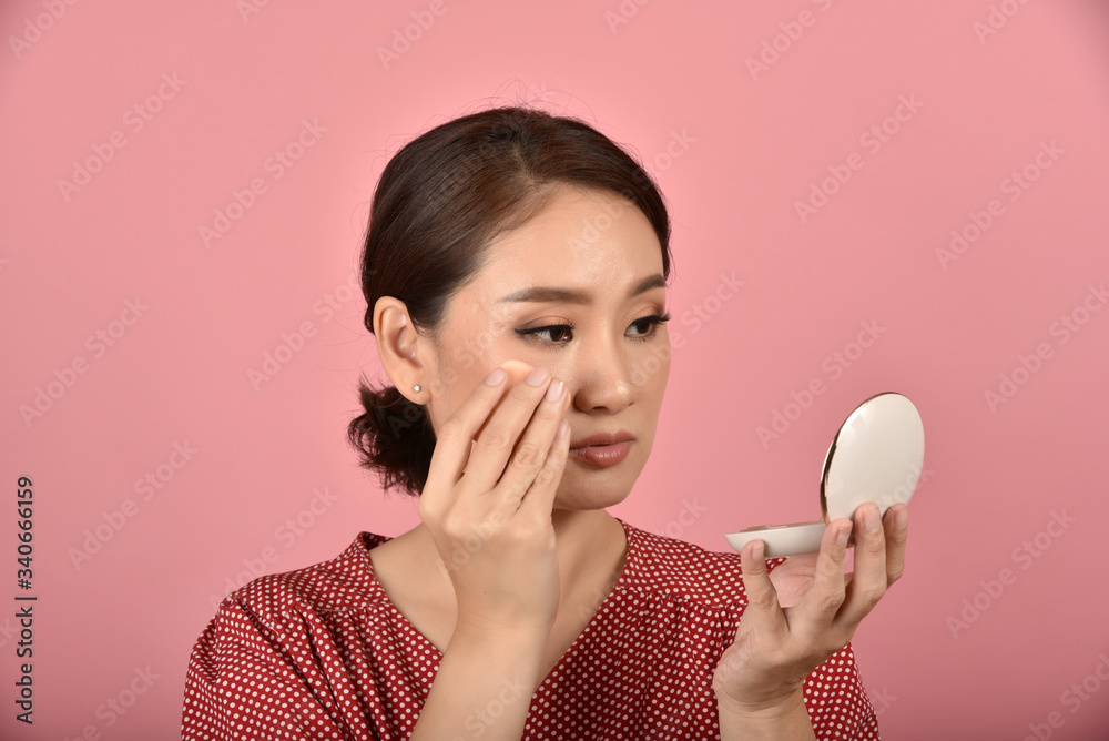 Asian woman looking at her facial problem in the mirror, Female feeling annoy about her reflection appearance show the aging skin signs, Makeup cover skin problem. Asian woman looking at her facial problem in the mirror, Female feeling annoy about her reflection appearance show the aging skin signs, Makeup cover skin problem.