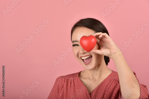 Gentle asian woman holding red heart, Happy smiling girl showing love sign to support and encourage, Cardiac health checkup. © ARTFULLY-79