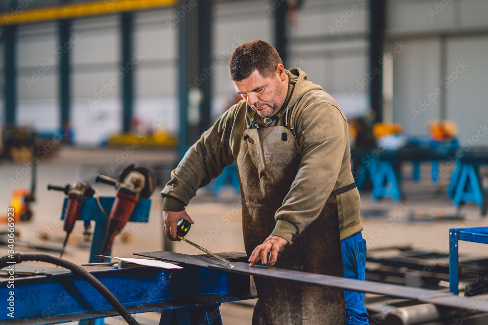 Industrial worker measuring the steel plate Industrial worker measuring the steel plate