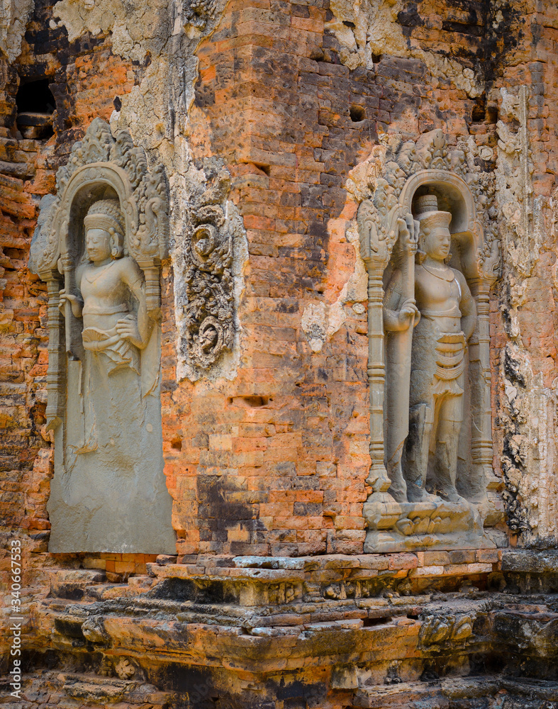 Obraz premium Detail of niche bas relief with male warrior sculpture decorating the walls of Preah Ko ancient hindu temple in Angkor Wat Unesco site, Siem Reap, Cambodia