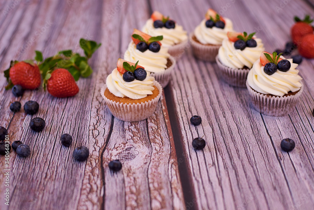 Cupcakes with strawberries and blueberries. Selective focus.
