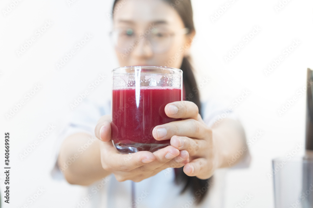 A cute girl makes vegetable juice, with carrot apple orange cranberry beetroot and mango in chef suit. A cute girl makes vegetable juice, with carrot apple orange cranberry beetroot and mango in chef suit.