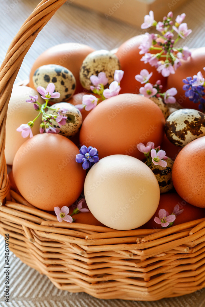 Wicker basket full of eggs decorated with spring flowers. Wicker basket full of eggs decorated with spring flowers.