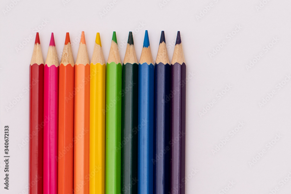 pencils of red, orange, yellow, green, azure, blue, and purple lie vertically on a white background in the shape of a rainbow pencils of red, orange, yellow, green, azure, blue, and purple lie vertically on a white background in the shape of a rainbow
