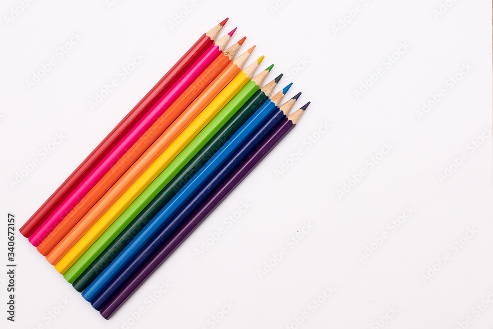 pencils of red, orange, yellow, green, azure, blue, and purple lie vertically on a white background in the shape of a rainbow pencils of red, orange, yellow, green, azure, blue, and purple lie vertically on a white background in the shape of a rainbow