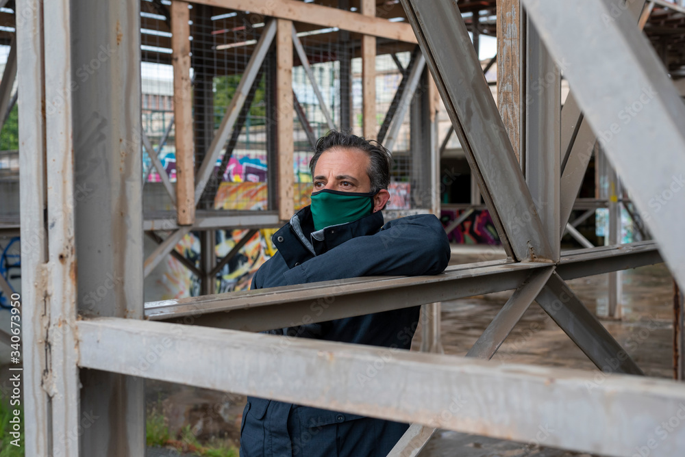 Man wearing mask and gloves during covid 19 pandemic standing and looking worried Man wearing mask and gloves during covid 19 pandemic standing and looking worried