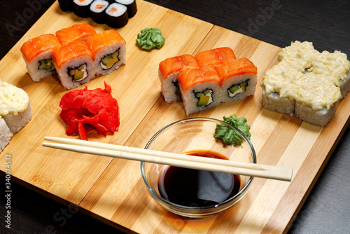 Tasty and delicious hot and cold sushi rolls on the table. Different sushi - rolls with sauce on the board of Japanese cuisine. photo