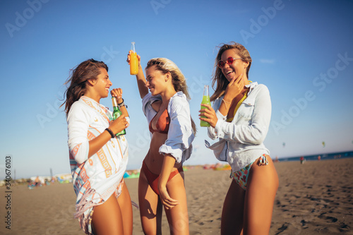 Group of three beautiful attractive young women having fun on the beach.