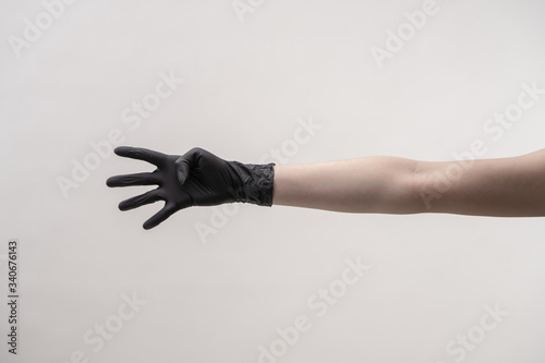 Hands in black silicone gloves on a light background.