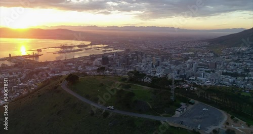 Aerial shot of the scenic port of a modern city at dusk, drone flying backwards while slowly ascending - Cape Town, South Africa