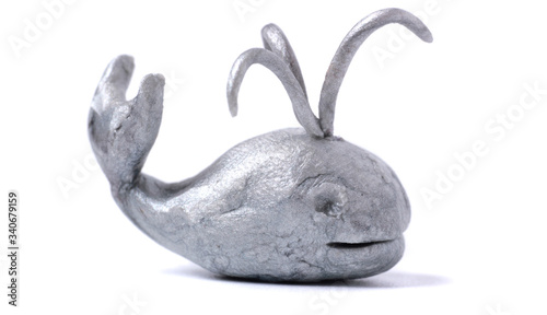 Plasticine cute silver 3d whale spraying water isolated on a white background.